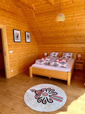 a bedroom with a bed in a wooden room at Sielska Chata Beskidy in Zawoja