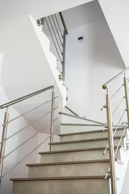 a staircase in a house with white walls and metal railings at Dom obok lasu pod Krakowem in Zabierzów