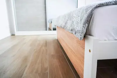 a bed in a room with a wooden floor at Dom obok lasu pod Krakowem in Zabierzów