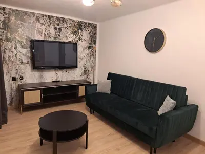 a living room with a green couch and a flat screen tv at Green Apartament in Oświęcim