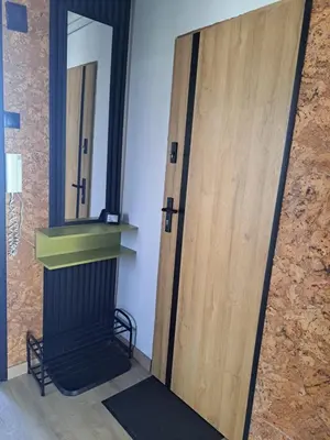 a bedroom with a bed and a desk and windows at Green Apartament in Oświęcim