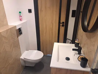 a kitchen with a counter with four stools at Green Apartament in Oświęcim