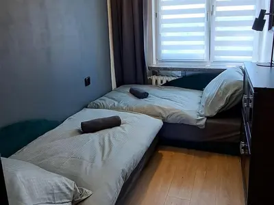 a bed with two pillows on it in a room at Green Apartament in Oświęcim