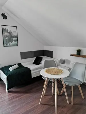 a room with a bed and a table and chairs at Srokówka Resort in Dąbrówka