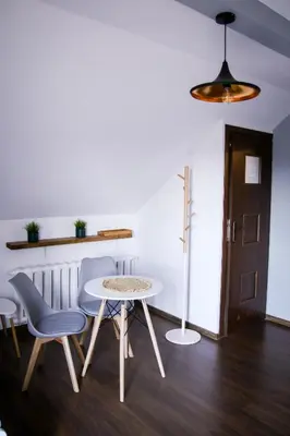 a room with a table and two chairs and a lamp at Srokówka Resort in Dąbrówka