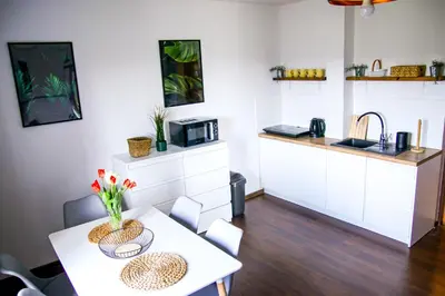 a small kitchen with a table and a microwave at Srokówka Resort in Dąbrówka