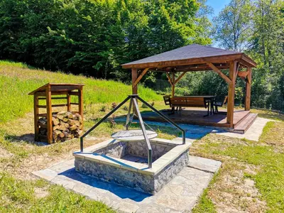a wooden gazebo with a fountain and a bench at Srokówka Resort in Dąbrówka
