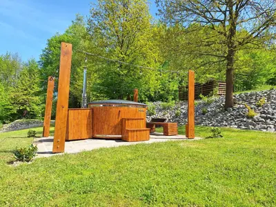 a large wooden structure in a park with grass at Srokówka Resort in Dąbrówka