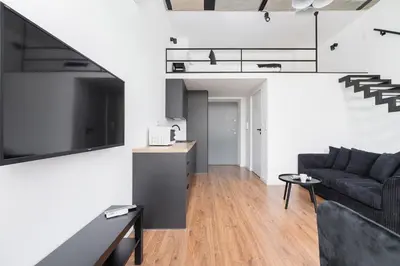 a living room with a couch and a tv at Kazimierz District - 43 Starowislna Street in Kraków