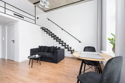 a living room with a couch and a table and chairs at Kazimierz District - 43 Starowislna Street in Kraków