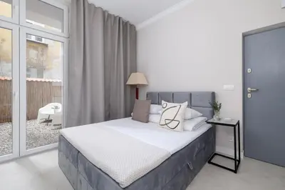 a bedroom with a bed with white sheets and pillows at Studio Apartment With Terrace -Starowślna 43 in Kraków