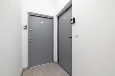 an empty corridor with two doors in a building at Studio Apartment With Terrace -Starowślna 43 in Kraków