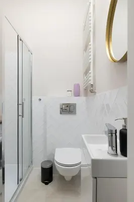 a white bathroom with a toilet and a sink at Studio Apartment With Terrace -Starowślna 43 in Kraków