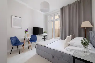 a white bedroom with a bed and a table and chairs at Studio Apartment With Terrace -Starowślna 43 in Kraków