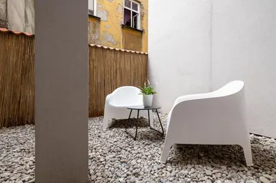 two white chairs and a table in a courtyard at Studio Apartment With Terrace -Starowślna 43 in Kraków
