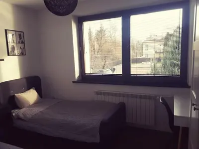 a small bedroom with a bed and a window at Apartament Roztoki 4a in Rabka-Zdroj