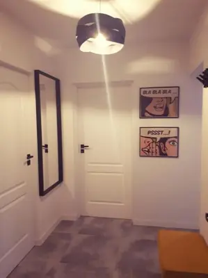 a hallway with a white door and a mirror at Apartament Roztoki 4a in Rabka-Zdroj