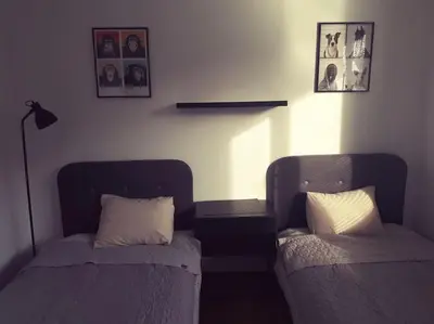 a bedroom with two beds and a lamp and pictures on the wall at Apartament Roztoki 4a in Rabka-Zdroj