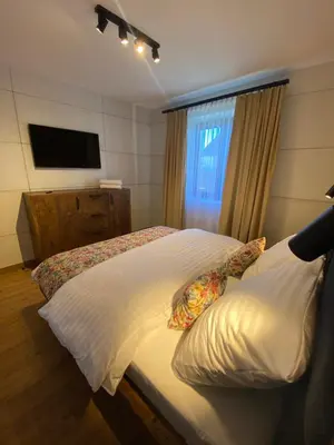 a bedroom with a white bed with a window at Zander Village Zator in Palczowice