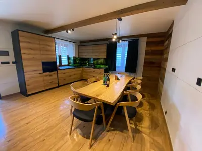 a dining room with a wooden table and chairs at Zander Village Zator in Palczowice