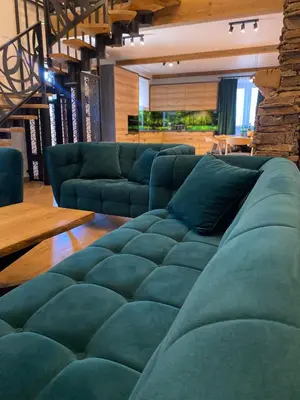a living room with a green couch and a table at Zander Village Zator in Palczowice