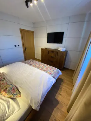 a bedroom with a bed and a flat screen tv at Zander Village Zator in Palczowice