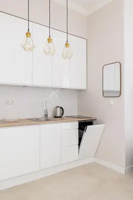 a white kitchen with white cabinets and lights at Studio for two - Kazimierz District - Starowiślna 43 in Kraków