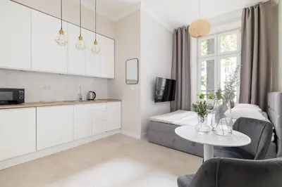 a kitchen and living room with a table and a couch at Studio for two - Kazimierz District - Starowiślna 43 in Kraków