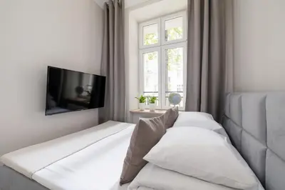 a white bedroom with a bed and a window at Studio for two - Kazimierz District - Starowiślna 43 in Kraków