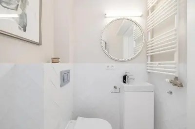 a white bathroom with a toilet and a mirror at Studio for two - Kazimierz District - Starowiślna 43 in Kraków