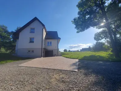 a white house with a driveway in front of it at Apartament u Majki in Bystra