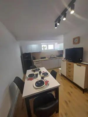 a living room with a couch and a table and chairs at Apartament u Majki in Bystra