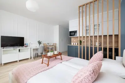 a bedroom with a large bed with a table at Pink & Blue Cozy Studio in Kraków by Noclegi Renters in Kraków