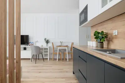 a kitchen with white cabinets and a table with chairs at Pink & Blue Cozy Studio in Kraków by Noclegi Renters in Kraków