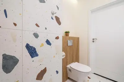 a bathroom with a toilet and a rock wall at Pink & Blue Cozy Studio in Kraków by Noclegi Renters in Kraków