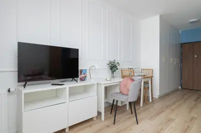 a living room with a desk with a television at Pink & Blue Cozy Studio in Kraków by Noclegi Renters in Kraków