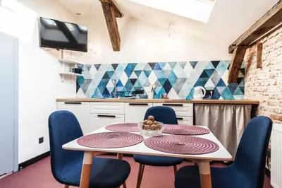 a kitchen with a table with chairs and a tv at 1-bedroom apartment with an AC - Dietla 51 street in Kraków