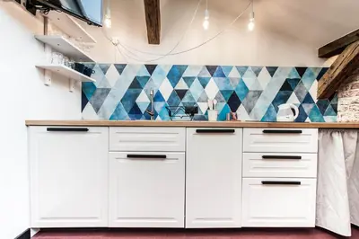 a kitchen with white cabinets and blue tiles at 1-bedroom apartment with an AC - Dietla 51 street in Kraków