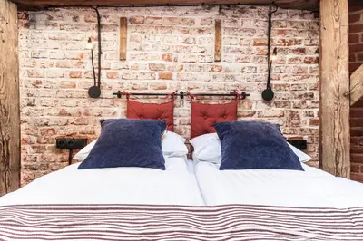 a bed in a room with a brick wall at 1-bedroom apartment with an AC - Dietla 51 street in Kraków