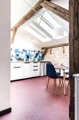 a kitchen with white cabinets and a table with a blue chair at 1-bedroom apartment with an AC - Dietla 51 street in Kraków