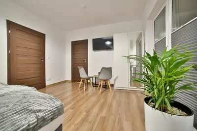 a bedroom with a bed and a wooden floor at Willa Bania Rabka Zdrój - Bezpłatny całodzienny basen - blisko centrum - Widok na Babią Górę in Rabka