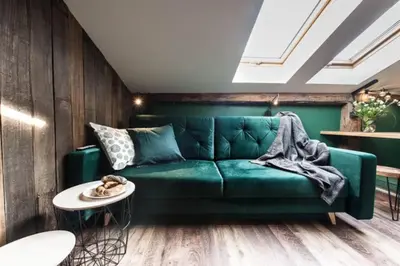 a green couch in a living room with a table at Studio with an AC - Dietla 51 street in Kraków