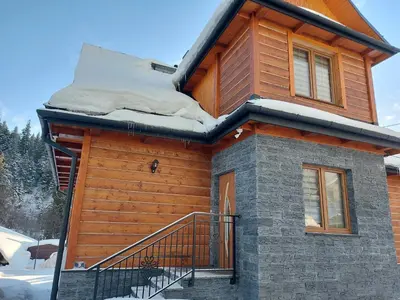 a log cabin with snow on the roof at Dom pod Turbaczem in Nowy Targ