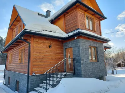 a log cabin with snow on the roof at Dom pod Turbaczem in Nowy Targ