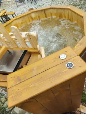 a wooden hot tub with a wooden table and water at Dom pod Turbaczem in Nowy Targ