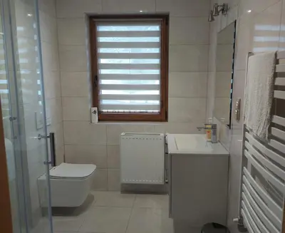 a bathroom with a toilet and a sink and a window at Dom pod Turbaczem in Nowy Targ