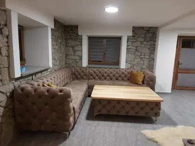 a living room with a brown couch and a table at Dom pod Turbaczem in Nowy Targ