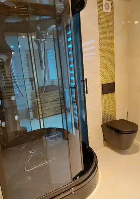 a shower with a black toilet in a room at Dom pod Turbaczem in Nowy Targ