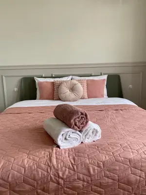 a bed with pink and white blankets and pillows at Royal Rose Apartment - Old Town Kraków in Kraków