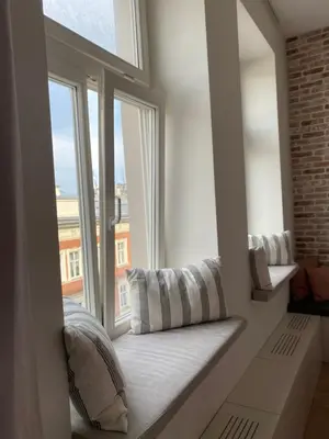 a window seat with pillows in front of a window at Royal Rose Apartment - Old Town Kraków in Kraków